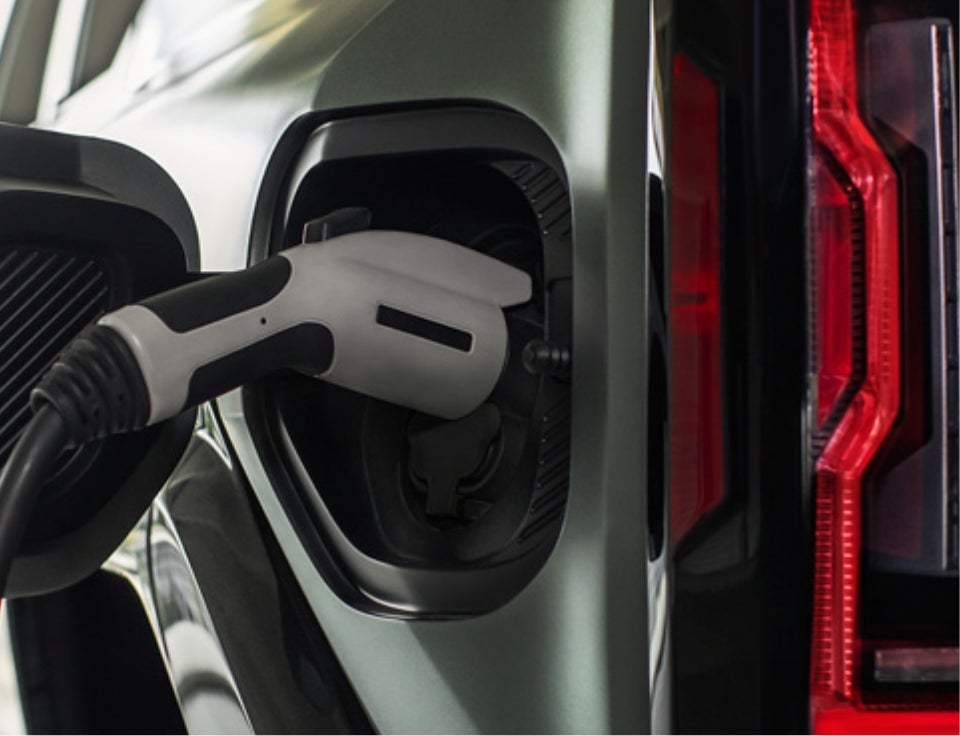 Close up of charging port with charger plugged in on a GMC Hummer EV SUV - Loveland Buick GMC in Loveland CO