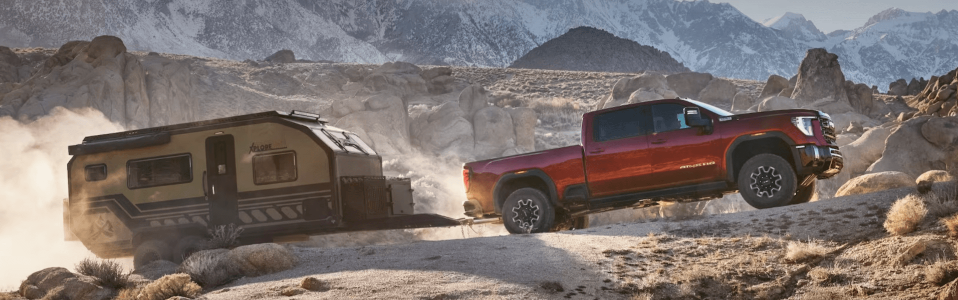 Red sierra 3500hd hauling trailer in desert